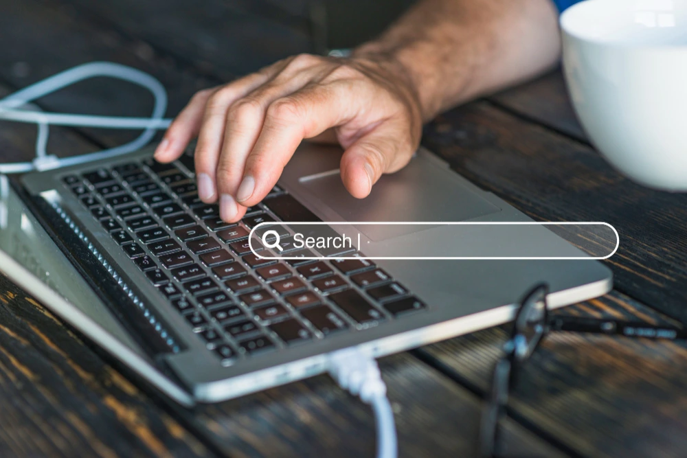 Close-up of a person using a search bar on a laptop, illustrating digital marketing and local SEO services.