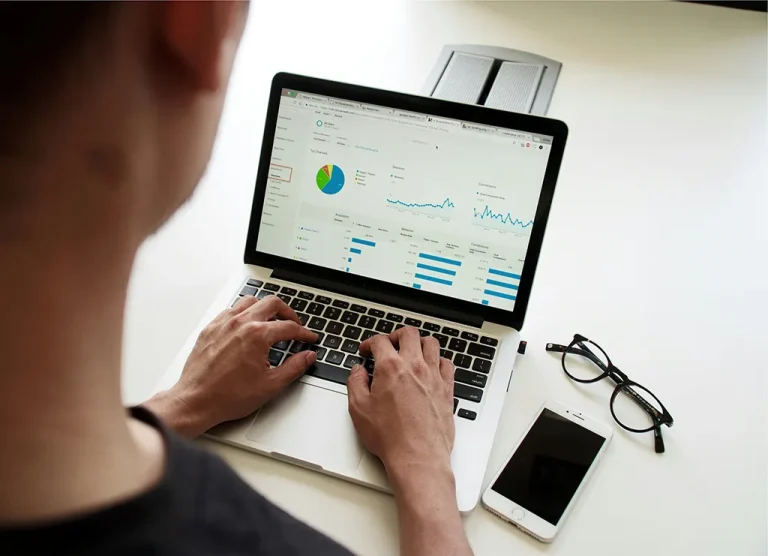A professional reviewing Google Analytics and SEO data dashboards on a laptop to identify technical website improvements.